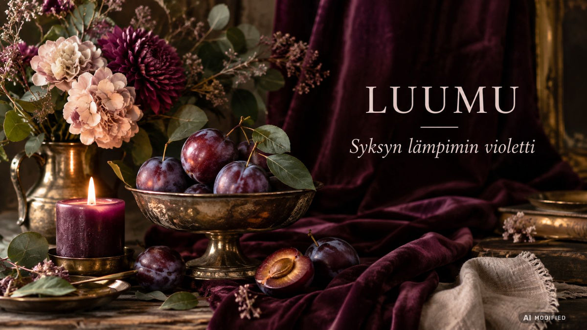 Kukkia ja luumuja sisälltävä hopeamalja pöydällä taiteellisena stille leben -asetelmana.
