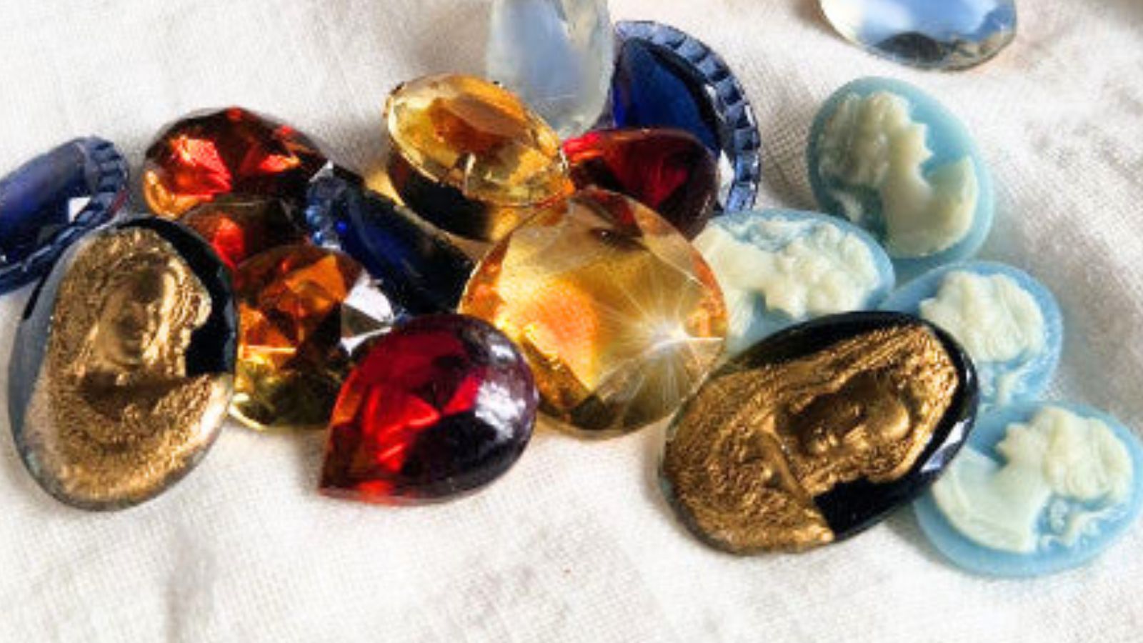 vintagehenkisten korujen materiaaleja: vintagelasia, kameita ja intarsiakapusseja